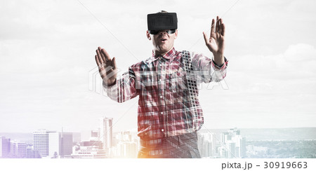 Guy wearing checked shirt and virtual mask stretching hands and trying to concentrate 30919663