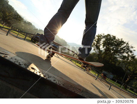 skateboarder legs practice ollie at skatepark ramp 30920076