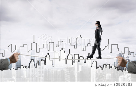 Business concept of risk support and assistance with man balancing on rope 30920582