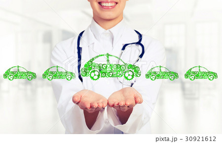 Close up of female hand showing car symbol made with gears and cogwheels Close up of female hand showing car symbol made with gears and cogwheels 30921612