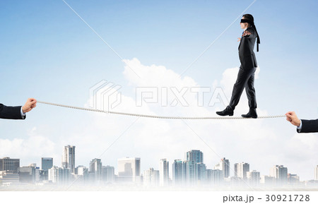 Business concept of risk support and assistance with man balancing on rope 30921728