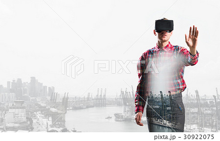 Guy wearing checked shirt and virtual mask stretching hand to touch something Guy wearing checked shirt and virtual mask stretching hand to touch something 30922075