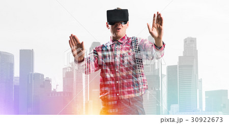 Guy wearing checked shirt and virtual mask stretching hand to touch something Guy wearing checked shirt and virtual mask stretching hand to touch something 30922673