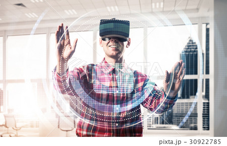 Young man in modern office interior experiencing virtual reality technology 30922785