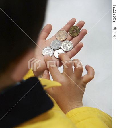 おつかい コインを数える男の子の写真素材