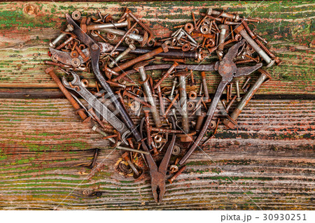 Heart of bolts and nuts on a wooden background 30930251