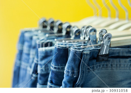 Row of hanged blue jeans in a shop Row of hanged blue jeans in a shop 30931058
