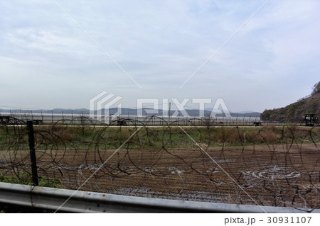 鉄条網や監視所で厳しく警備されている韓国の軍事境界線付近の道路 鉄条網や監視所で厳しく警備されている韓国の軍事境界線付近の道路 30931107