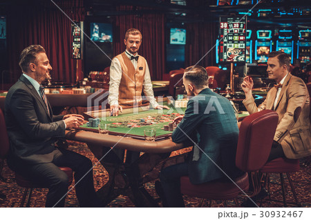 Upper class friends gambling in a casino Upper class friends gambling in a casino 30932467