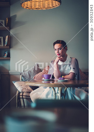 Elegant young lady alone in a cafe 30932843