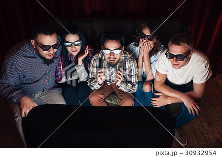 People in 3d glasses watch tv, amazed by effects 30932954