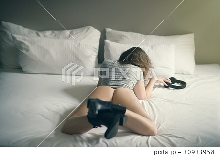 Beautiful naked girl lies on a bed in headphones Beautiful naked girl lies on a bed in headphones 30933958