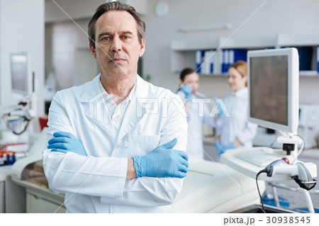 Serious male person crossing arms on chest Serious male person crossing arms on chest 30938545
