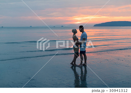 Couple Embracing On Beach At Sunset, Young Tourist 30941312