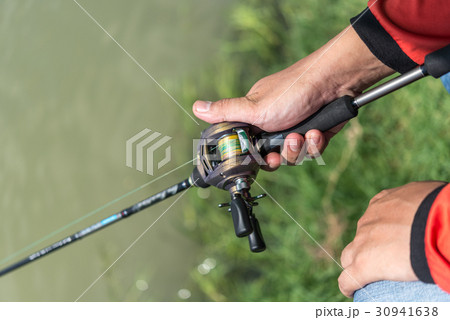 釣り ベイトリールと釣竿を持つ手の写真素材
