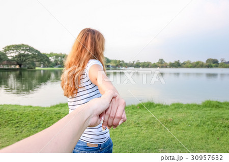 Back view of a couple taking a walk holding hands Back view of a couple taking a walk holding hands 30957632