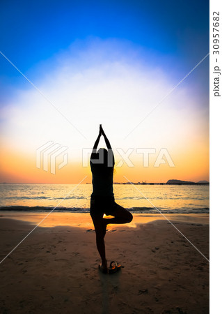 Silhouette woman yoga on the beach over the sunset Silhouette woman yoga on the beach over the sunset 30957682