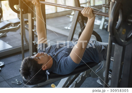 Young Asian man exercising in the fitness gym Young Asian man exercising in the fitness gym 30958305