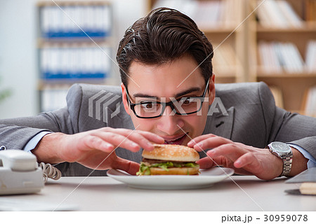 Hungry funny businessman eating junk food sandwich 30959078