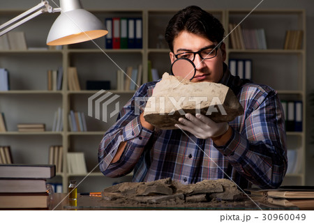 Archeologist working late night in office 30960049