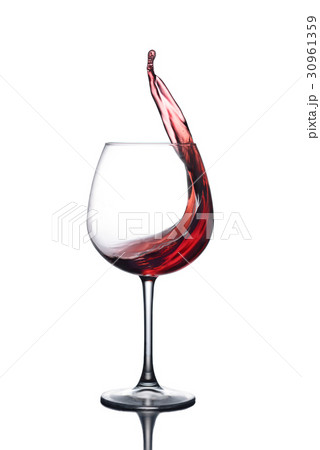 Splash of red wine in a glass on a white backgroun 30961359