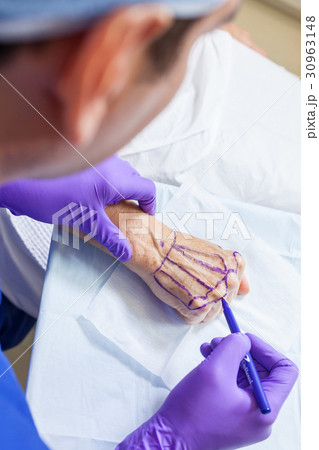 Plastic Surgeon Doctor Marks Hand of Senior Woman Plastic Surgeon Doctor Marks Hand of Senior Woman 30963148