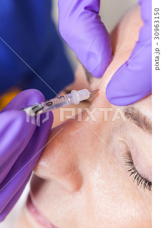 Cosmetic Surgeon Doctor Giving Botox to Woman Face Cosmetic Surgeon Doctor Giving Botox to Woman Face 30963150