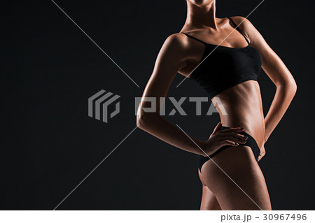 Muscular young woman athlete on black 30967496