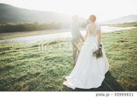 Newly married couple running and jumping in park Newly married couple running and jumping in park 30969831