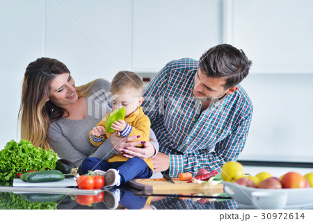 Happy family preparing vegetables together at home Happy family preparing vegetables together at home 30972614