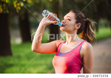 Thirsty woman drinking water to recuperate after 30973358