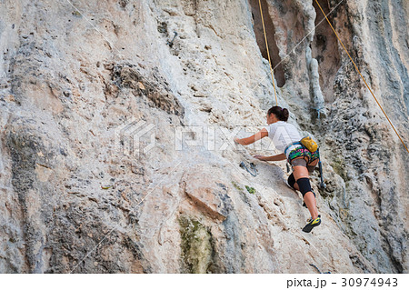 Young woman rock climbing on white mountain 30974943