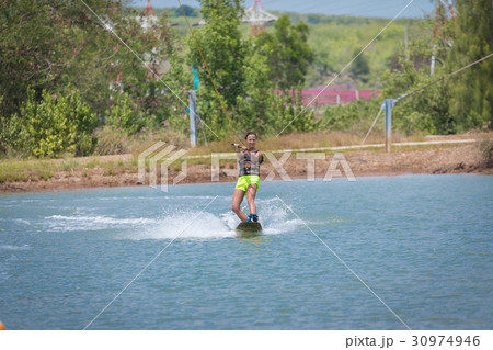Woman study wakeboarding on a blue lake Woman study wakeboarding on a blue lake 30974946