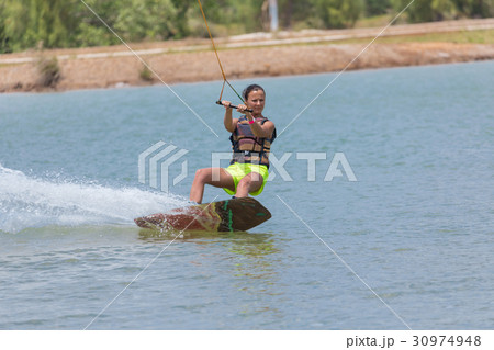 Woman study wakeboarding on a blue lake 30974948