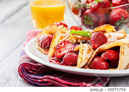 Traditional crepes served with strawberries Traditional crepes served with strawberries 30975756