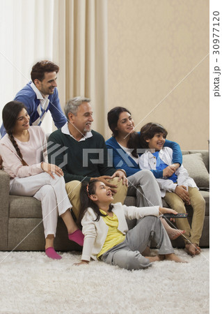 Happy family watching television in living room 30977120