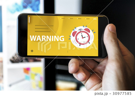 Hands with illustration of alarm clock notification for important appointment on mobile phone 30977585