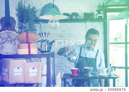 Senior adult man barista making coffee in cafe 30980979