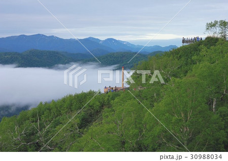 北海道占冠村トマムの山間部に流れ込んだ雲海越しに日高山脈の絶景を展望台から見る観光客 北海道占冠村トマムの山間部に流れ込んだ雲海越しに日高山脈の絶景を展望台から見る観光客 30988034