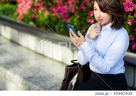 スマホを見て考える女性 30992936
