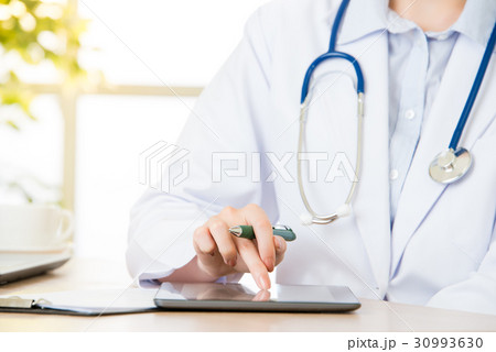 doctor using digital tablet to research patient's 30993630