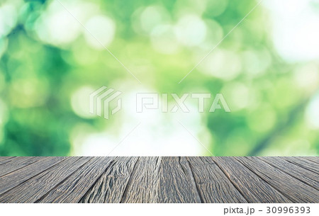 Empty wooden floor with green bokeh and sunlight 30996393