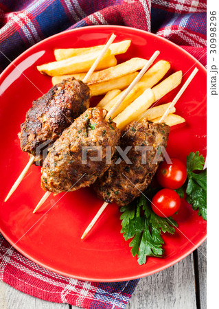 Barbecued kofta with fries on a plate 30998296