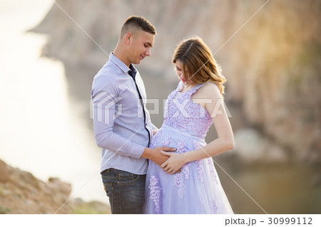 Couple pregnant girl and boy on the cliff Couple pregnant girl and boy on the cliff 30999112