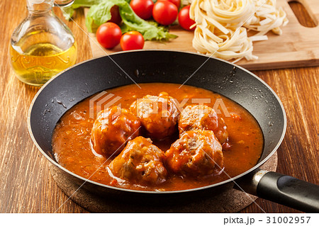 Meatballs with tomato sauce on black pan 31002957