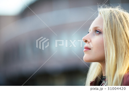 Profile portrait of young beautiful blond woman in city street o 31004420