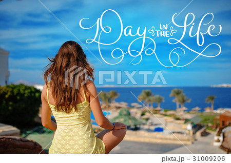 woman in yellow sundress looks at the sea and text 31009206