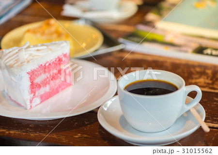 A cup of  coffee and a piece of cake. 31015562