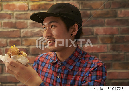 ハンバーガーを食べる男性の写真素材