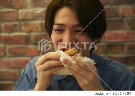 ハンバーガーを食べる男性の写真素材